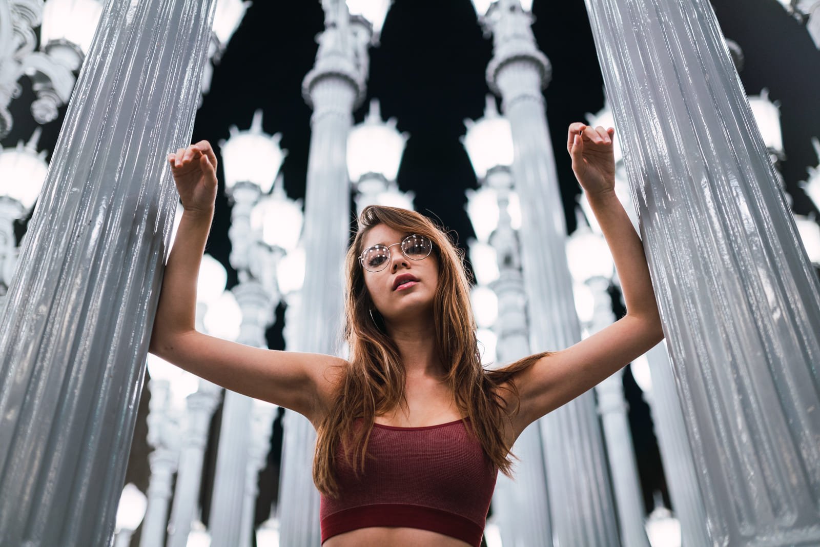 Modelo en medio de columnas blancas, foto tomada desde ángulo inferior